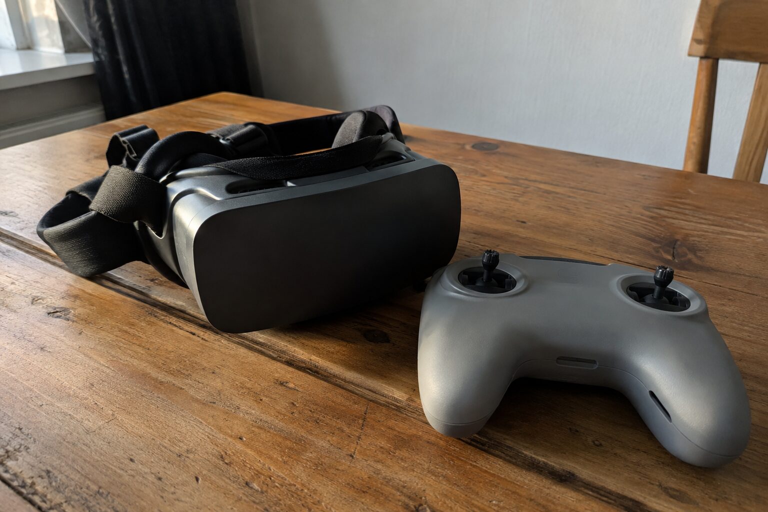 FPV-videobril op een houten tafel naast een controller